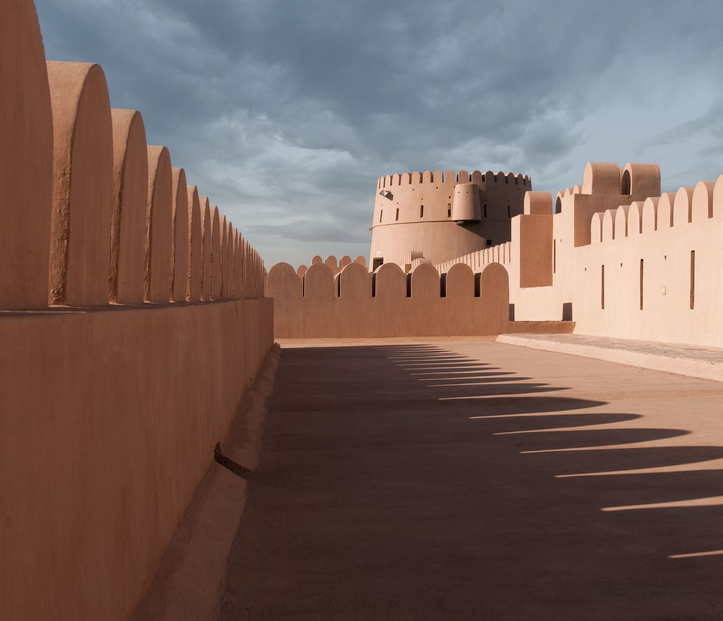 Les ombres des créneaux révèlent de la tour principale du fort de Nizwa
