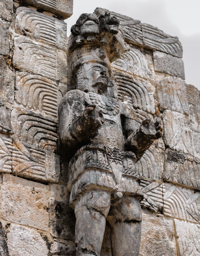 Steinerne Kriegerfigur an der Fassade des Palastes der Masken in Kabah