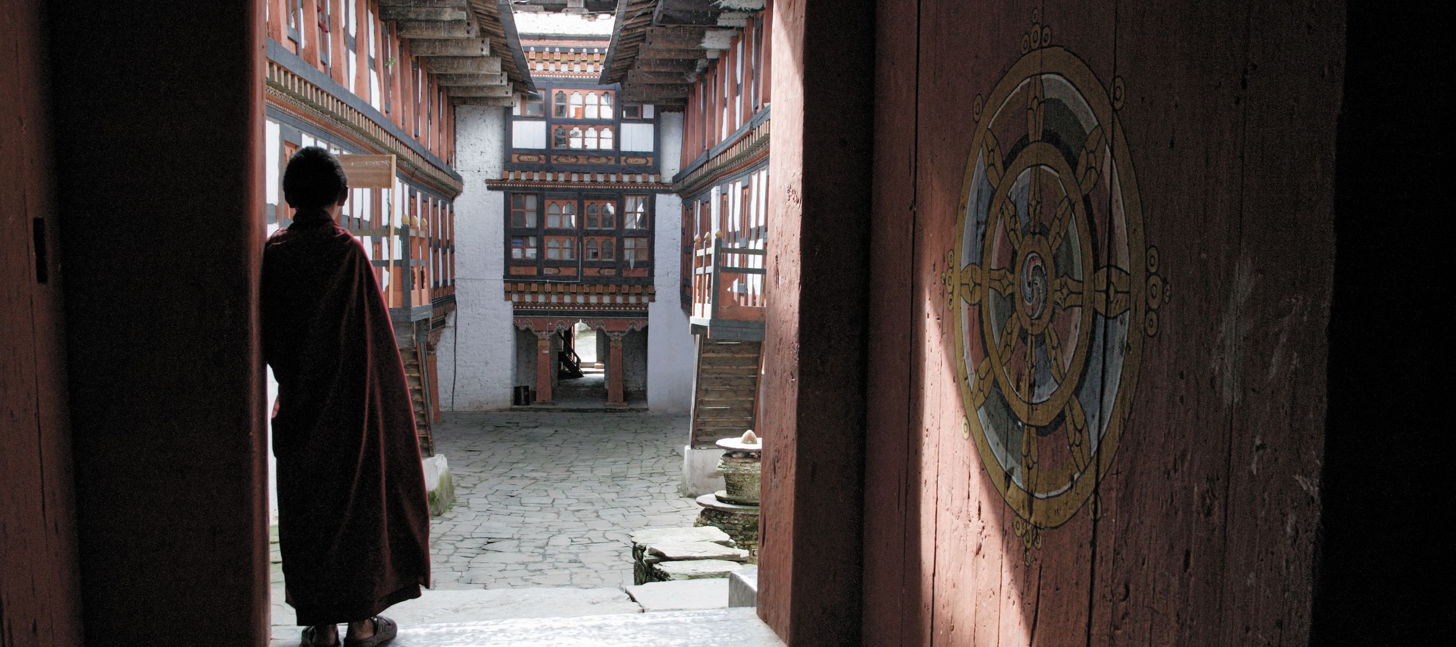 Bhutan, Bumthang, Jambay Lhakhang Dzong, Mönch im Eingang stehend