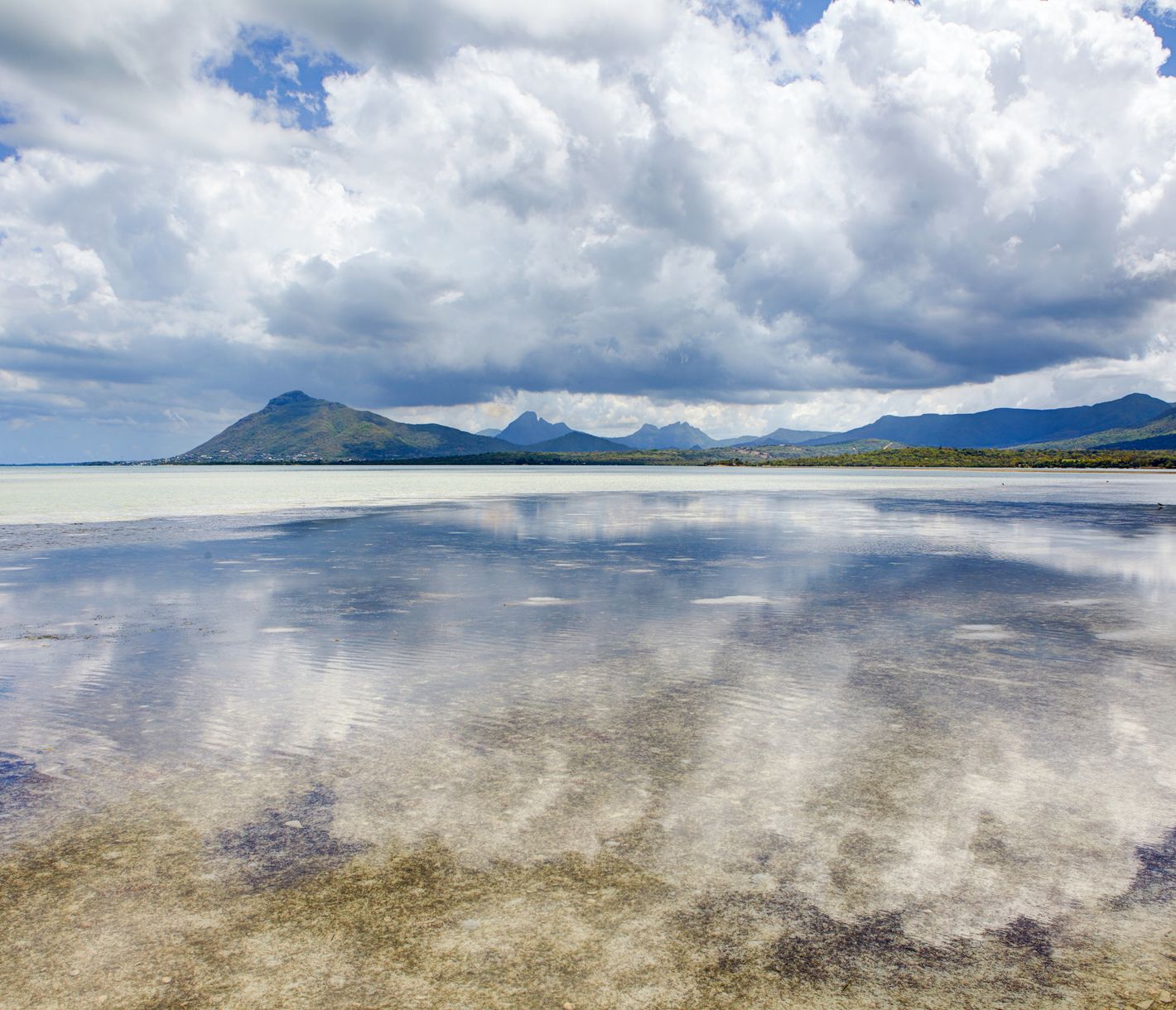 Der Himmel spiegelt sich auf der spiegelglatten Oberfläche des Indischen Ozeans vor der île aux Benitiers.
