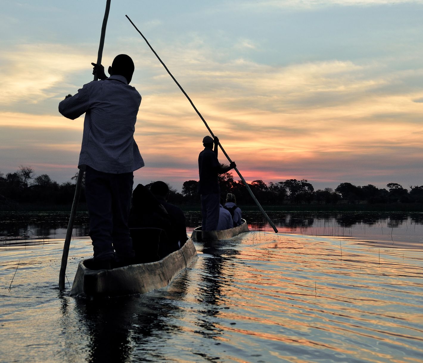 Fahrt in einem Mokoro in den Sonnenuntergang im Okavango-Delta