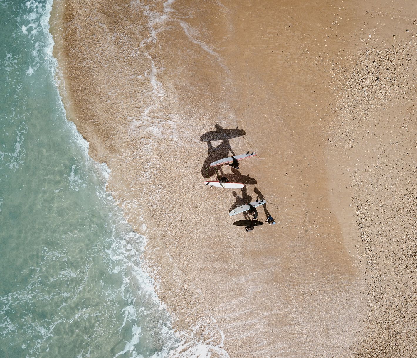 An zahlreichen Stränden der kalifornischen Küste gleiten Surfer über dem Wasser.