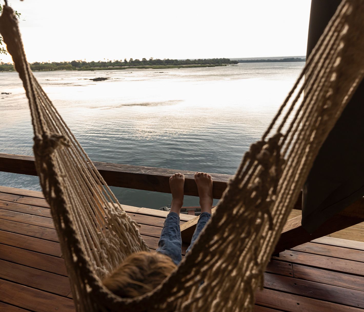 Entspannung in der Hängematte entlang dem Sambesi-Fluss in der Abenddämmerung