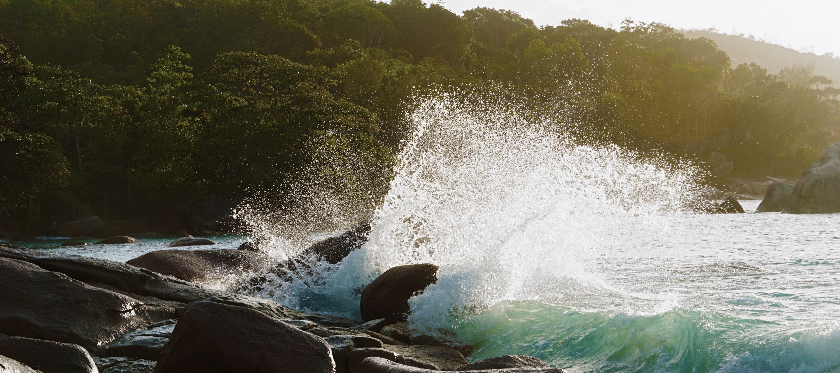 Wellen brechen an Granitfelsen am bekannten Strand Anse Lazio auf Praslin.