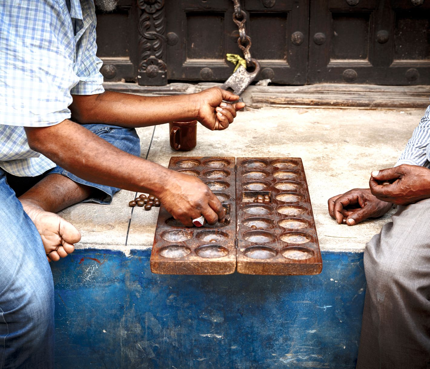 Zwei Sansibari beim Bao-Spiel in Stone Towns engen Gassen