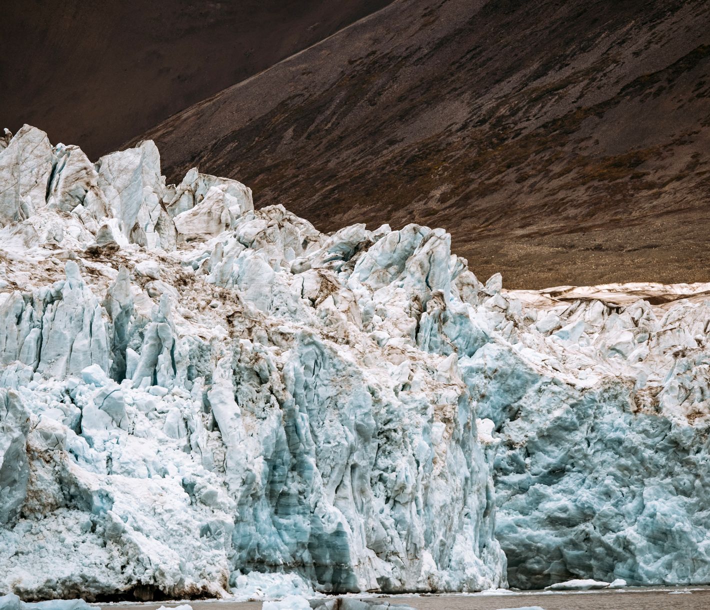 Gletschereis vor dunklen schroffen Bergen