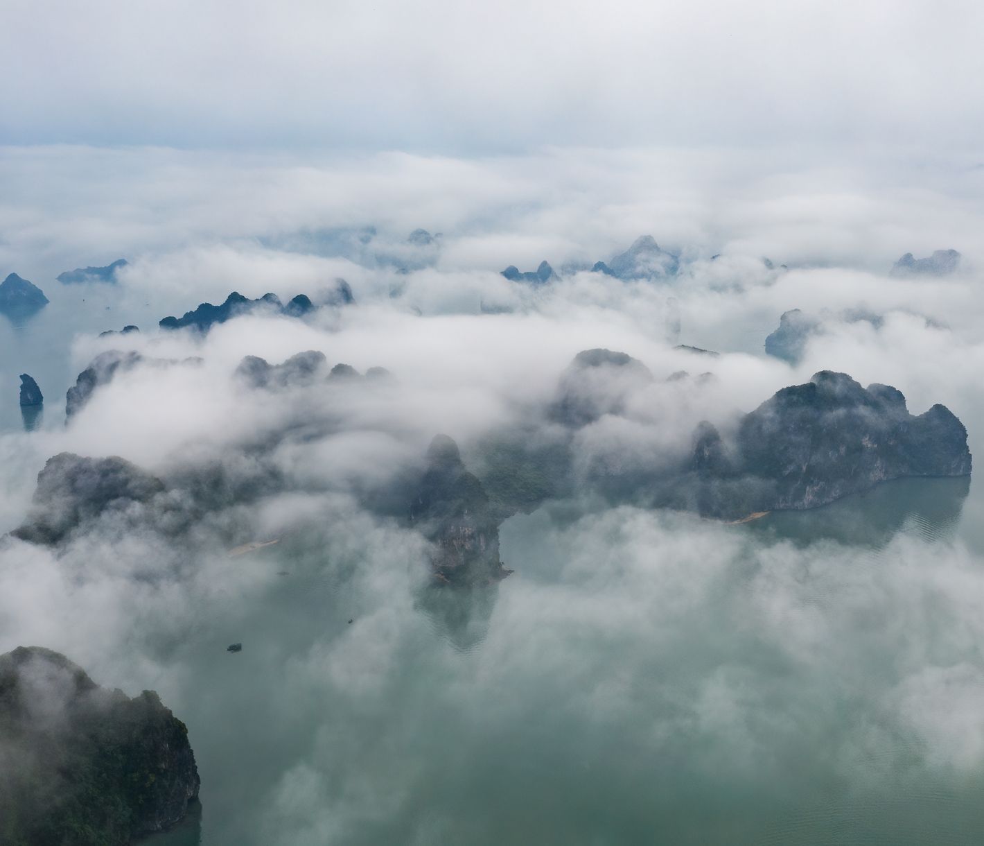 Die mystische Halong-Bucht in Nebel gehüllt. Die Grenze zwischen Nebel und Wolken ist indes diffus.
