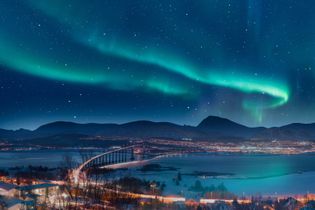 Nordlichter über Tromsø zeigen ein faszinierendes Farbenspiel am Himmel, das Besuchemde in Staunen versetzt und die Schönheit der Natur offenbart.