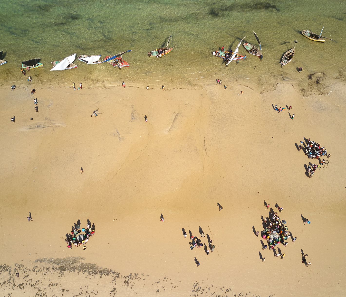 Leute beim Fisch kaufen am Strand von Vilanculos