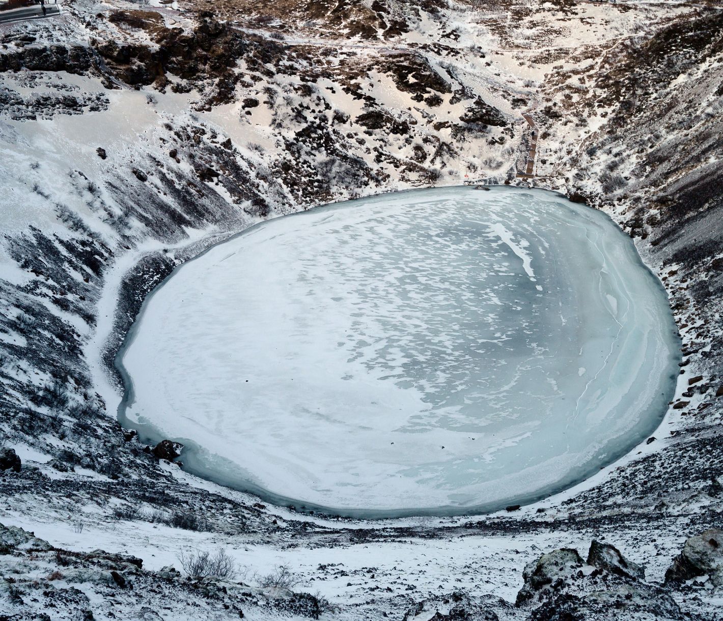 Ein blau-weisses Auge in der Winterlandschaft – der Kerid-Krater