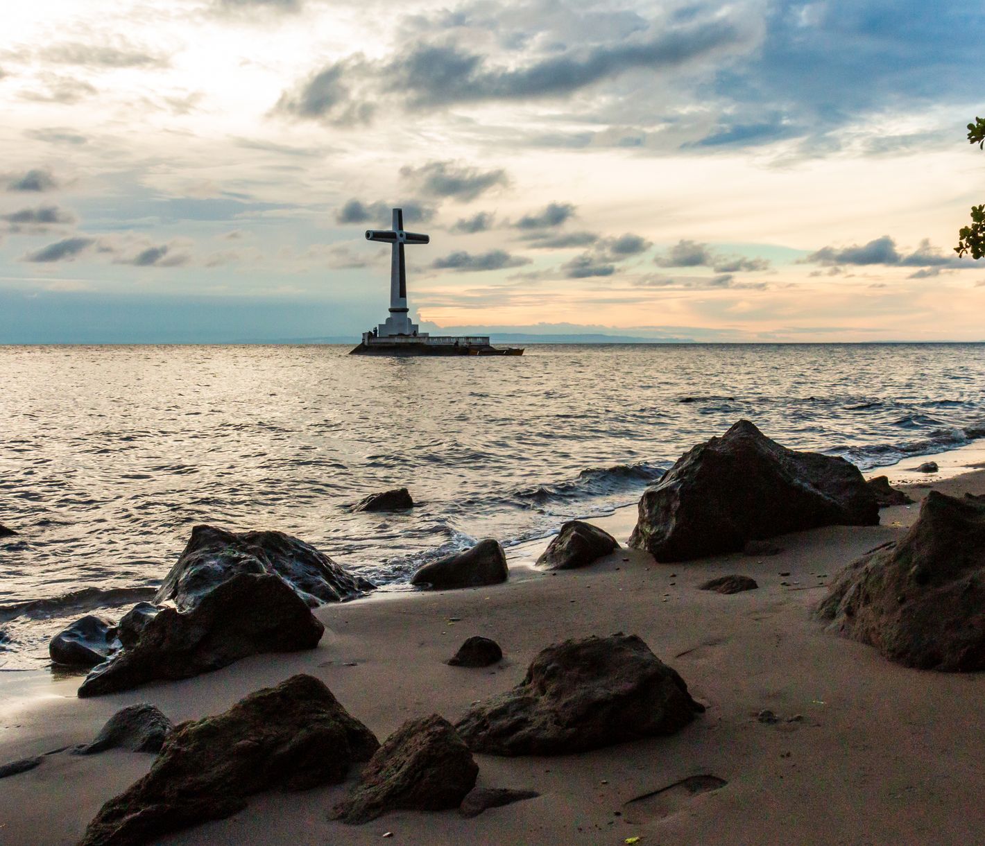 Ein grosses weisses Kreuz markiert die Stelle eines versunkenen Friedhofs.