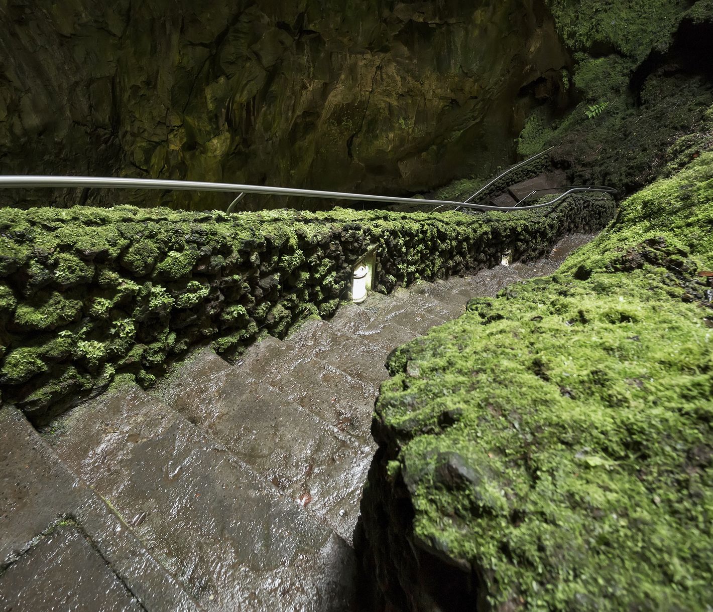 Eine Treppe, die in das Innere der Vulkanhöhle Algar do Carvão auf der Insel Terceira führt.