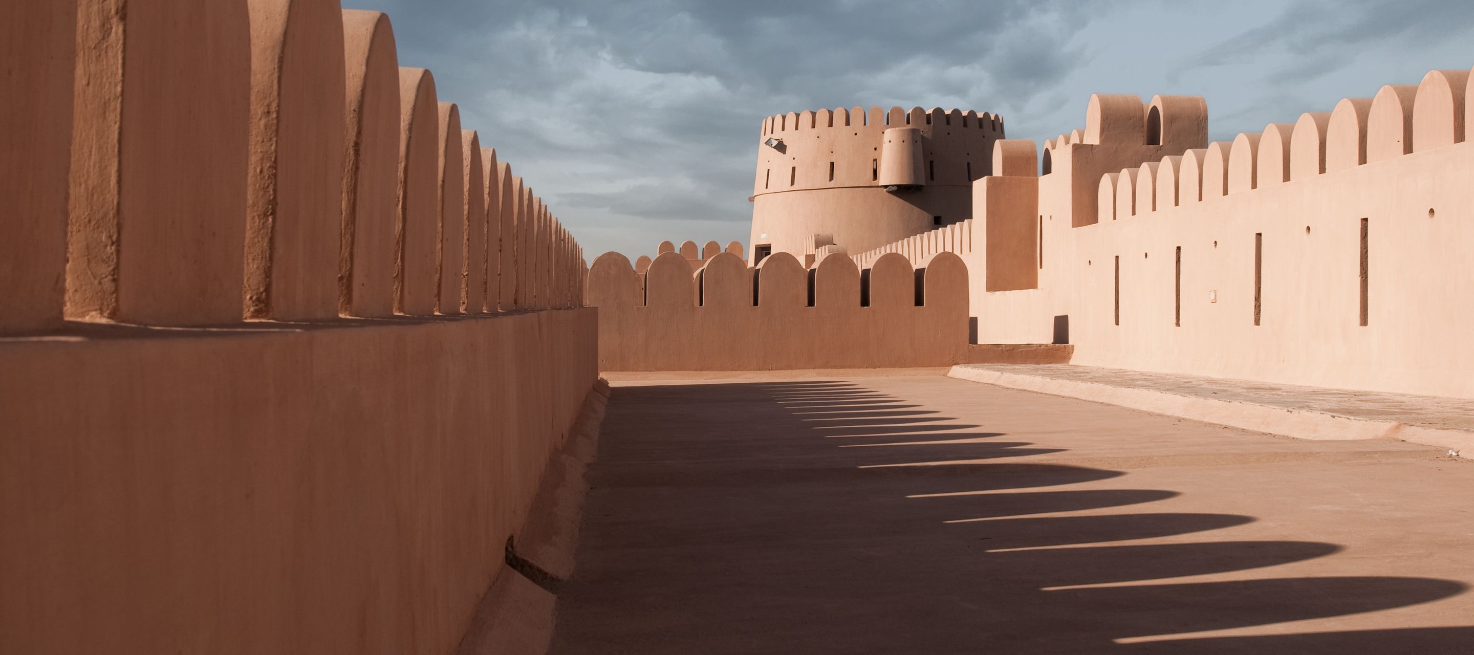 Les ombres des créneaux révèlent de la tour principale du fort de Nizwa
