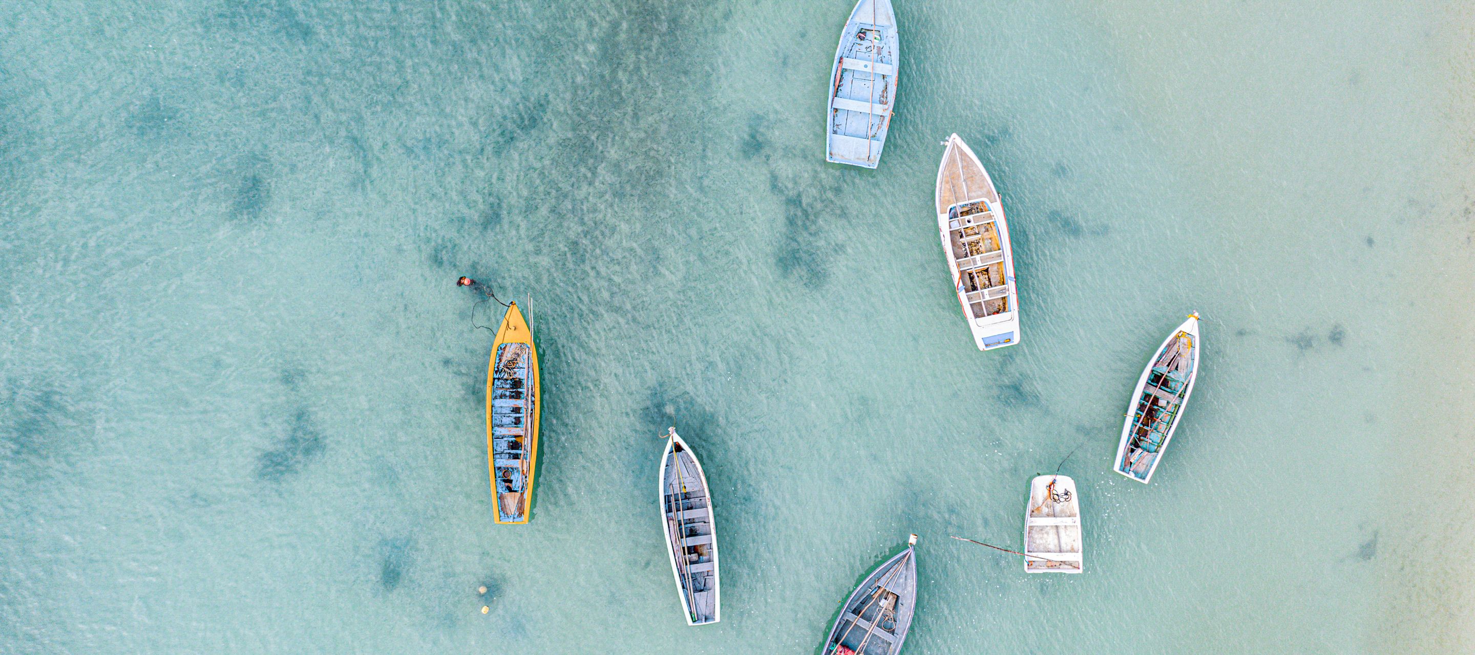 Farbige Fischerboote auf dem ruhigen Meer vor Mont Choisy