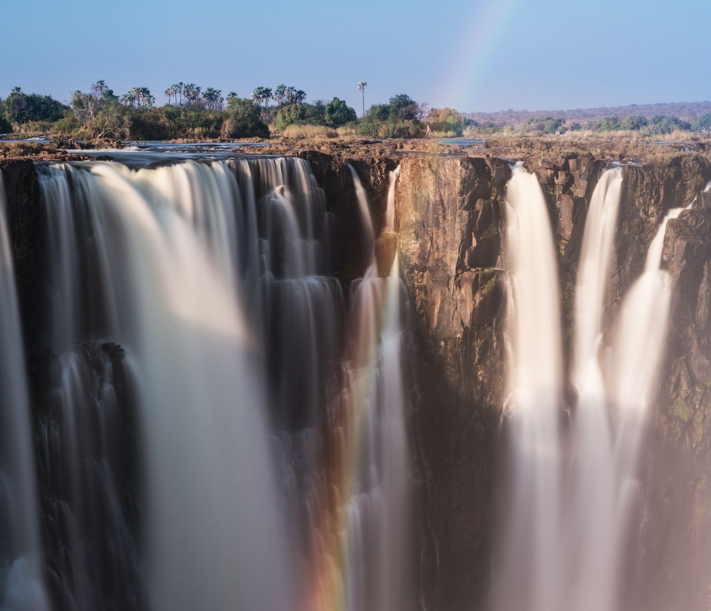 Die bekannten Victoriafälle in Simbabwe mit einem Regenbogen