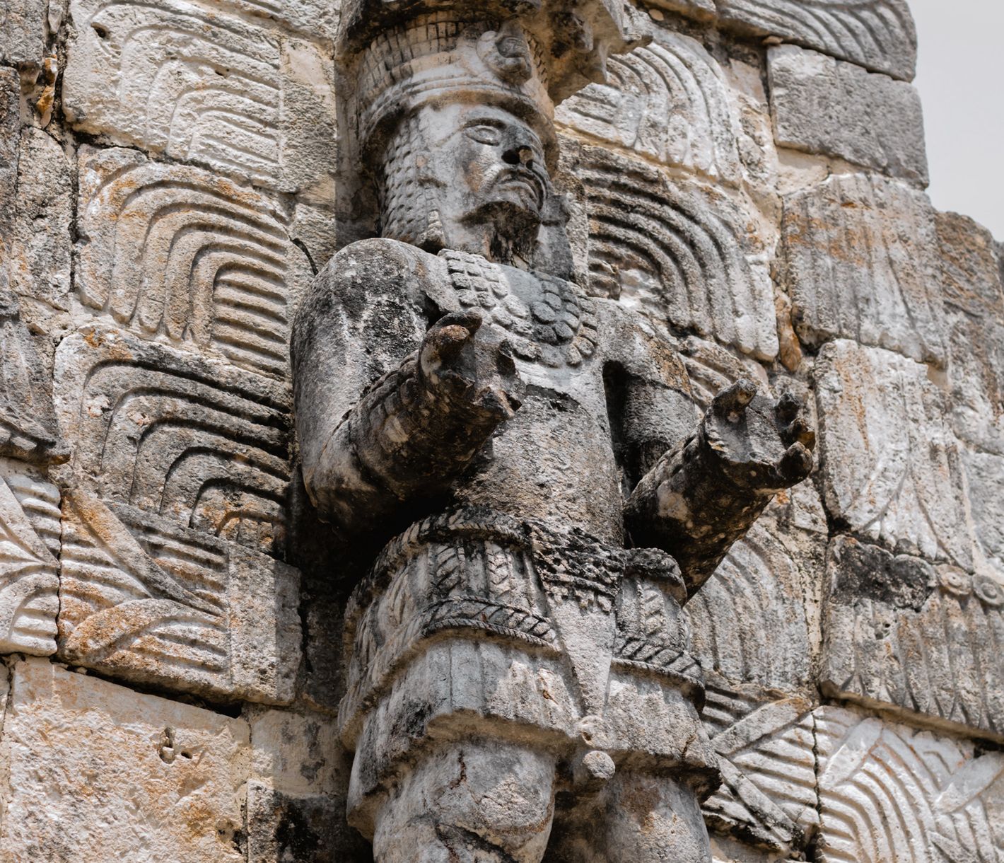 Steinerne Kriegerfigur an der Fassade des Palastes der Masken in Kabah