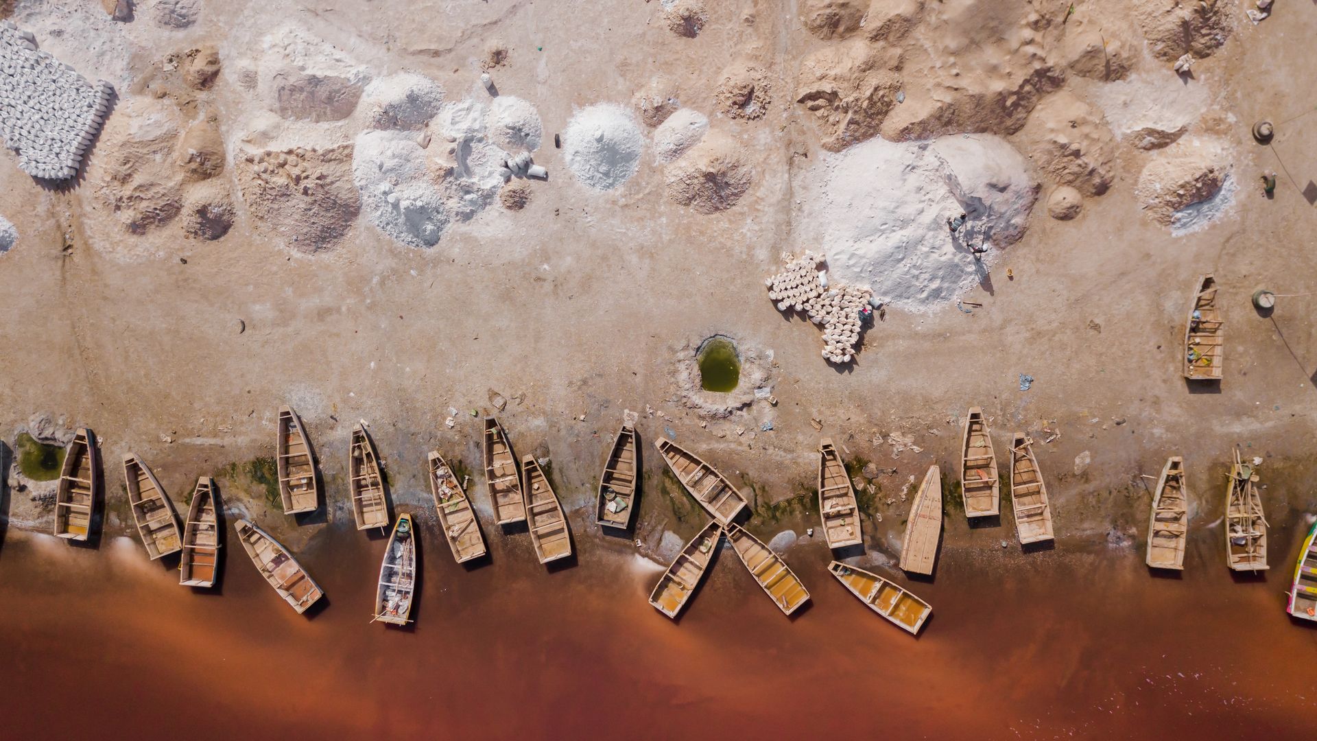 Boote am Ufer des rosa schimmernden Lac Rose
