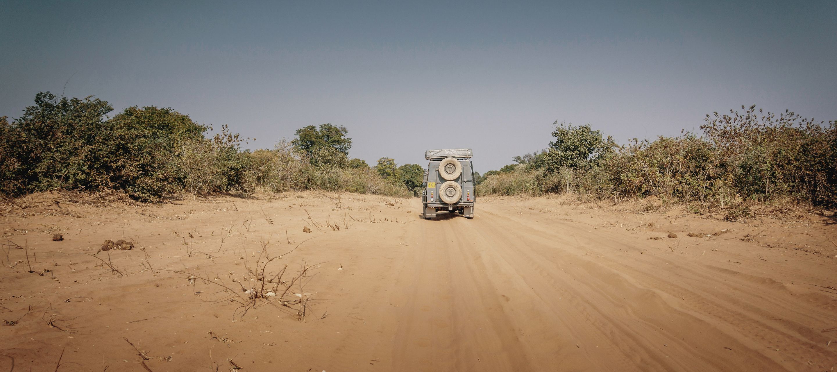 Ein 4x4-Fahrzeug fährt auf sandiger Piste im Chobe
