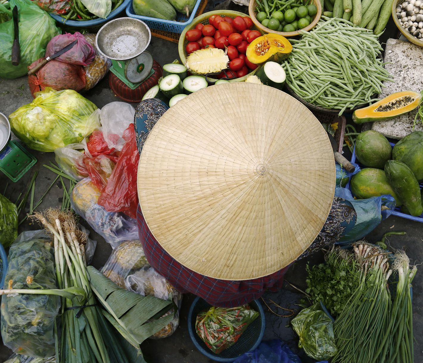 Eine Strassenhändlerin hat ihre Produkte um sich herum arrangiert und ist bereit für den Verkauf.