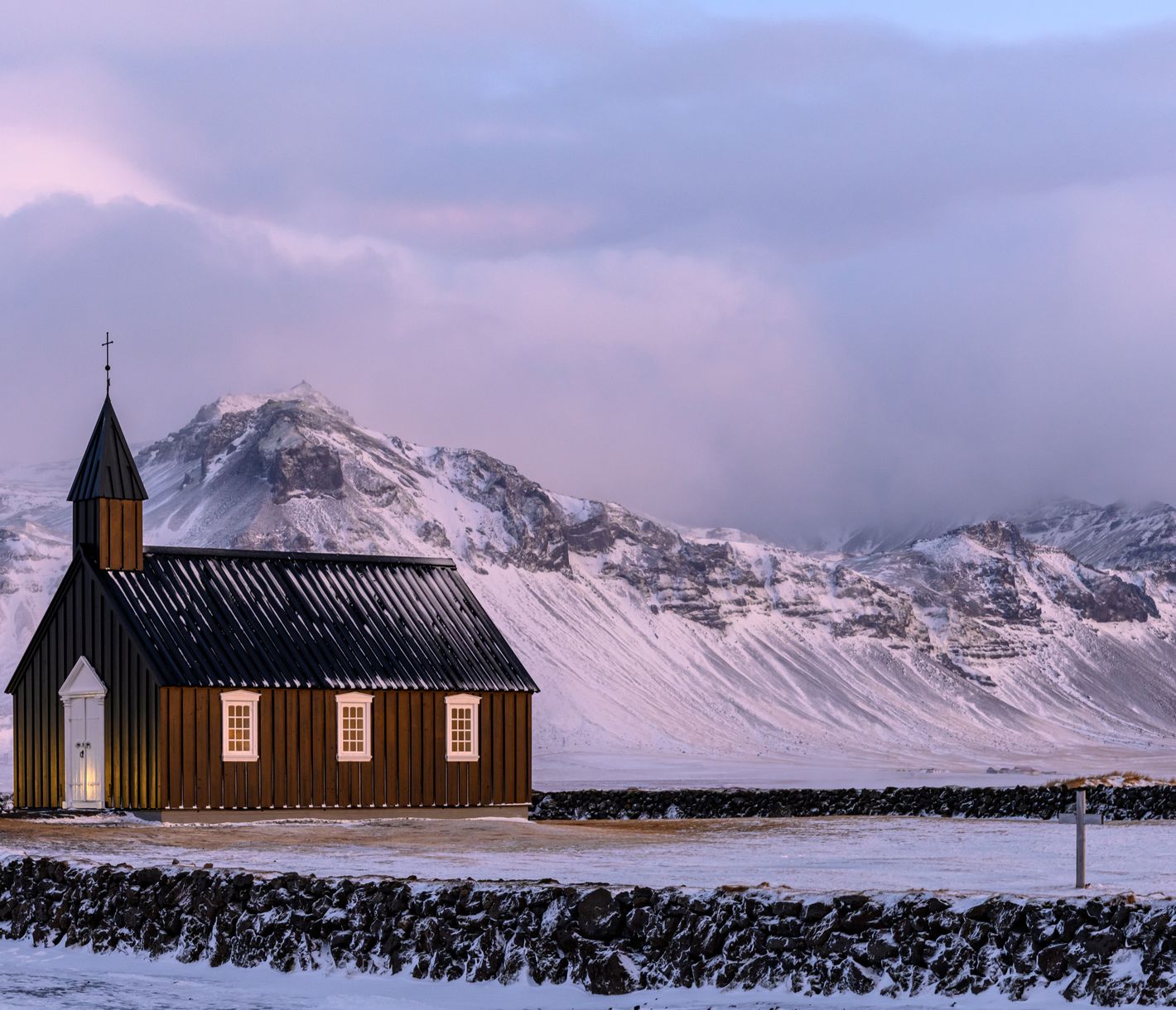 Der Kontrast der schwarzen Kirche zu den weissen Schneebergen im Hintergrund ist sehr eindrücklich.