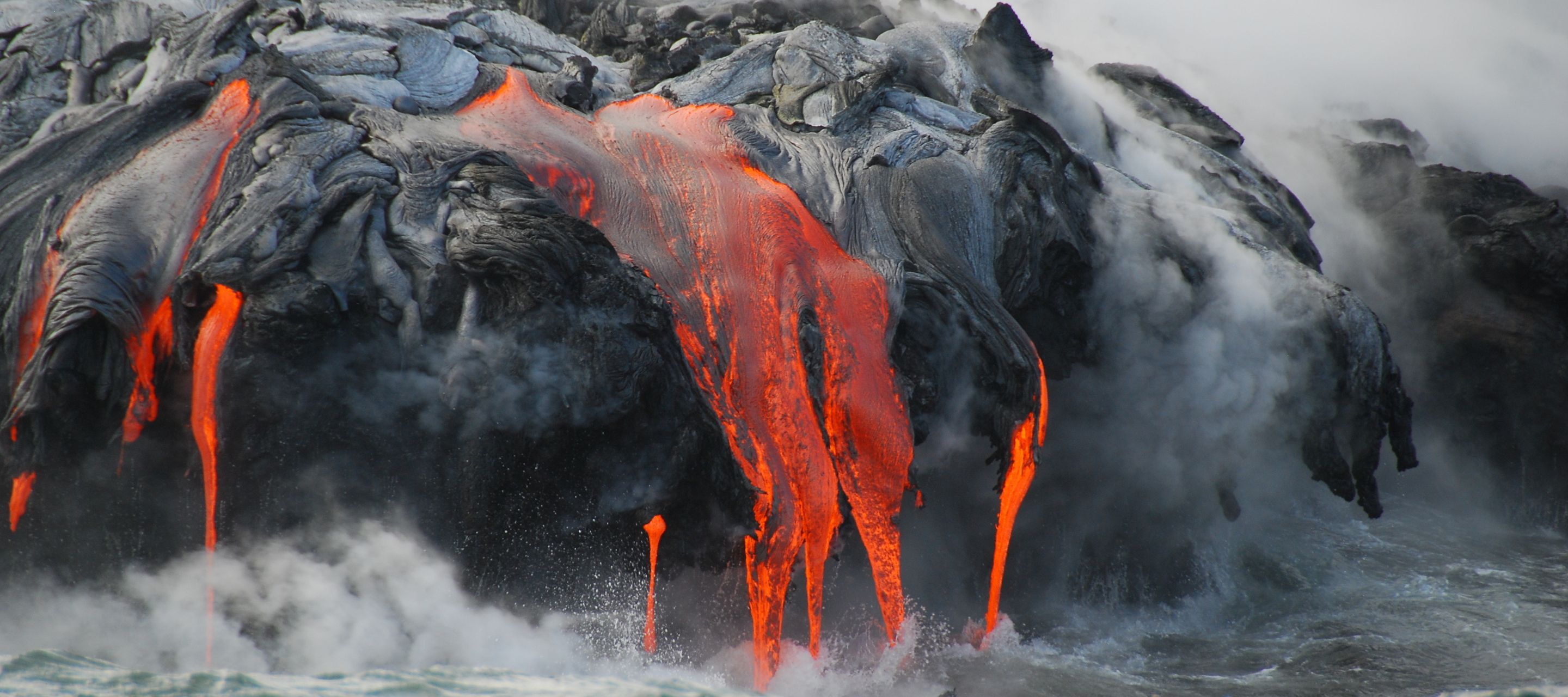 Champs de lave, cratères de volcans et cônes de cendres caractérisent le paysage mystique du Parc National des Volcans.