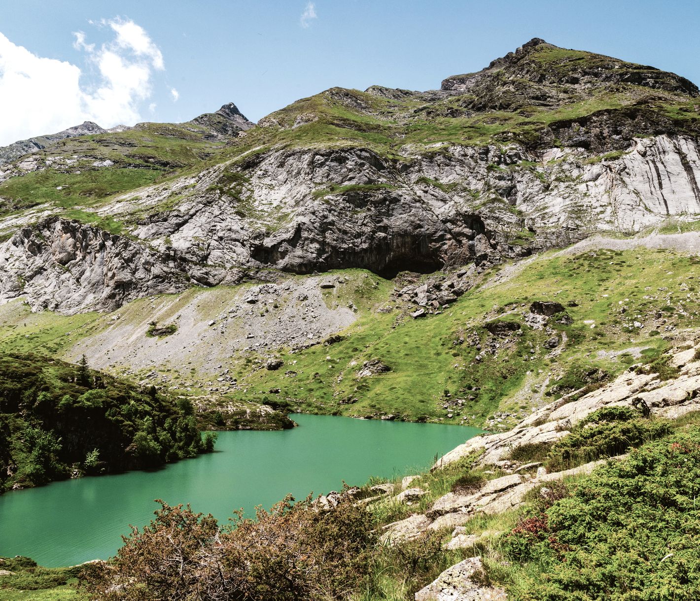 Sous la protection de l’Astazou (3 000 m), le sentier grimpe dans un paysage presque lunaire d’herbes rases et d’éboulis jusqu’à la hourquette d’Alans. Dans la descente par le plateau des Cardous, le paysage se fait alors plus doux et verdoyant.