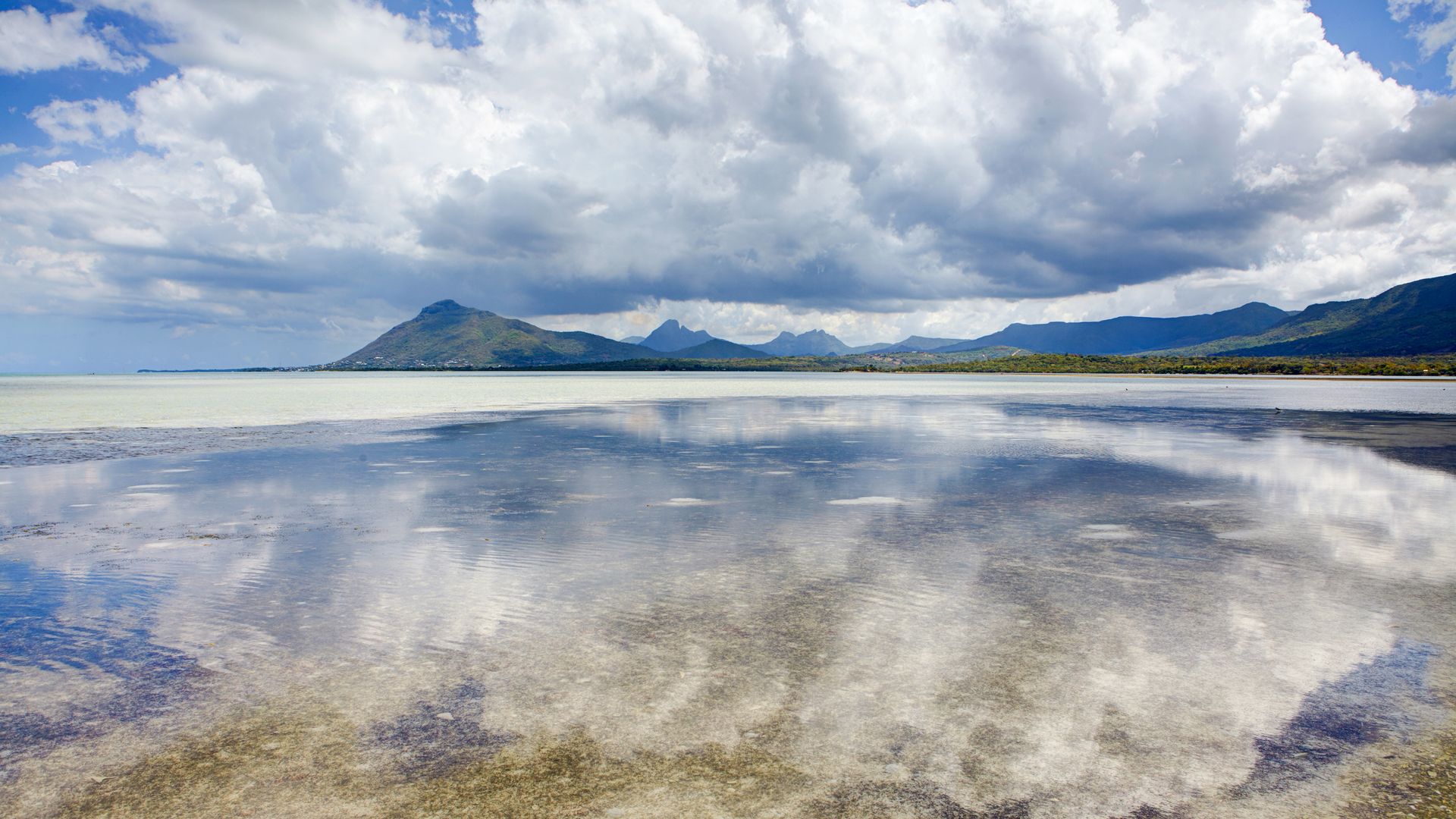 Der Himmel spiegelt sich auf der spiegelglatten Oberfläche des Indischen Ozeans vor der île aux Benitiers.