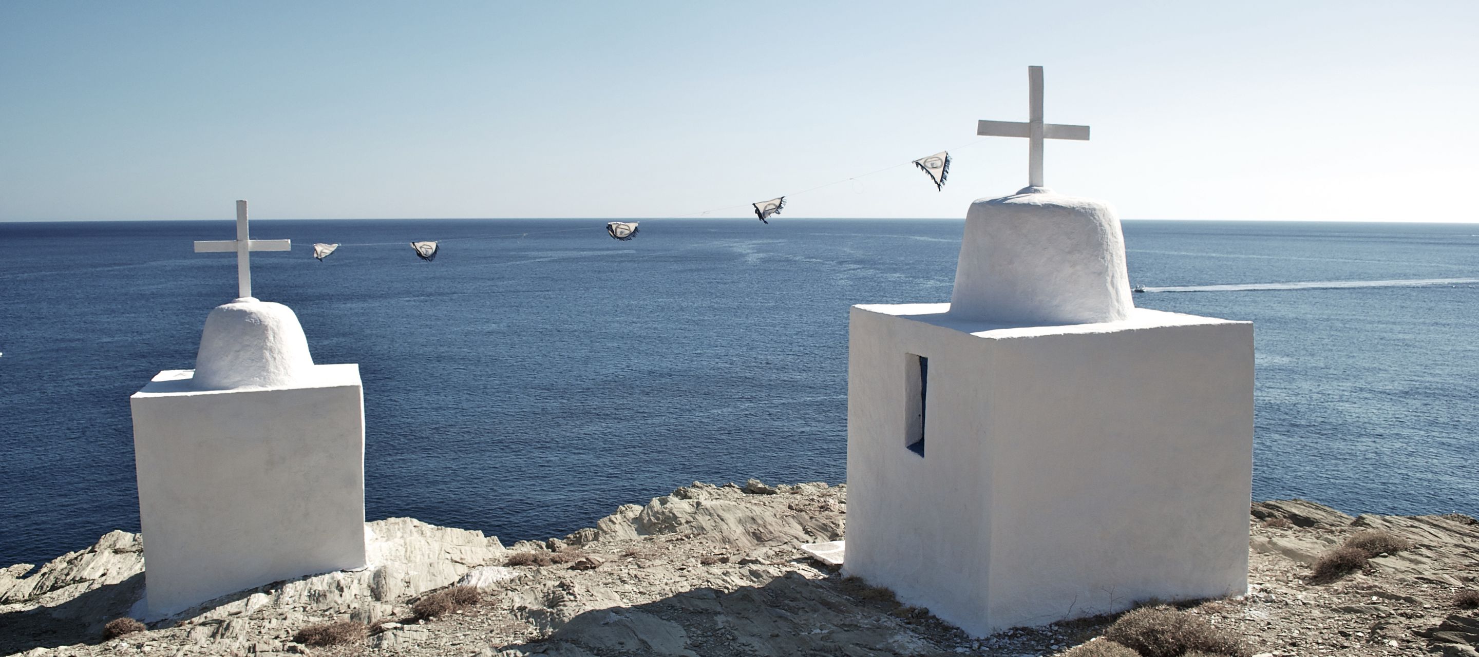 Zwei typische griechische Kapellen auf einem Felsen nahe dem Meer
