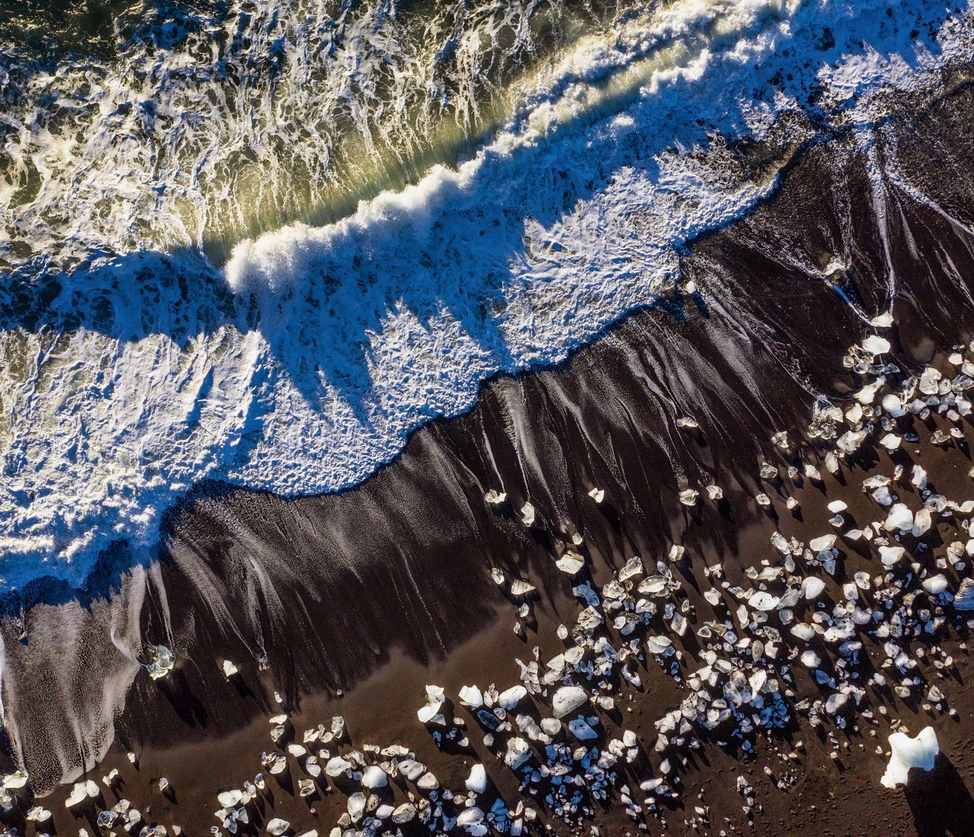 Wenn sich schwarzer Vulkansand mit kristallklaren Eisformationen abwechselt