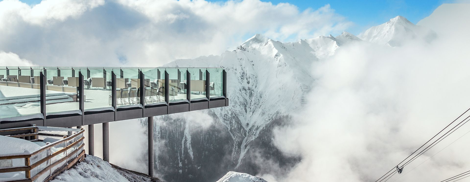 Aussichtsterrasse mit Blick auf die verschneiten Gipfel