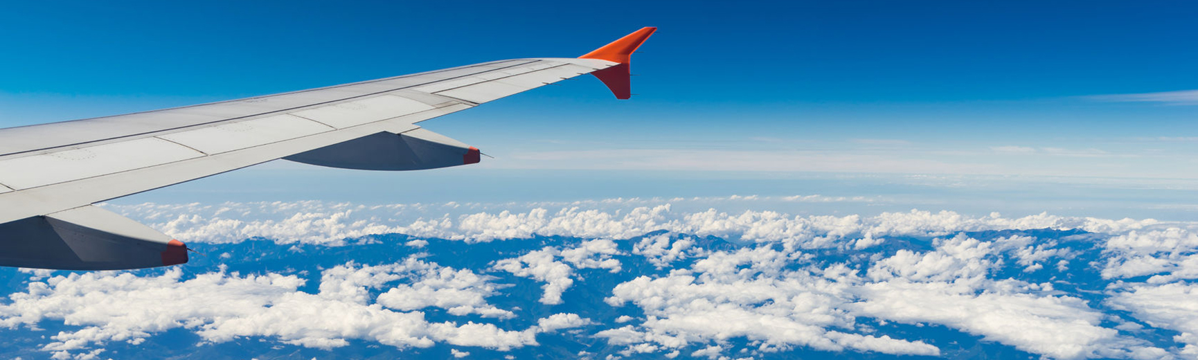 Flugzeugflügel am Wolkenhimmel