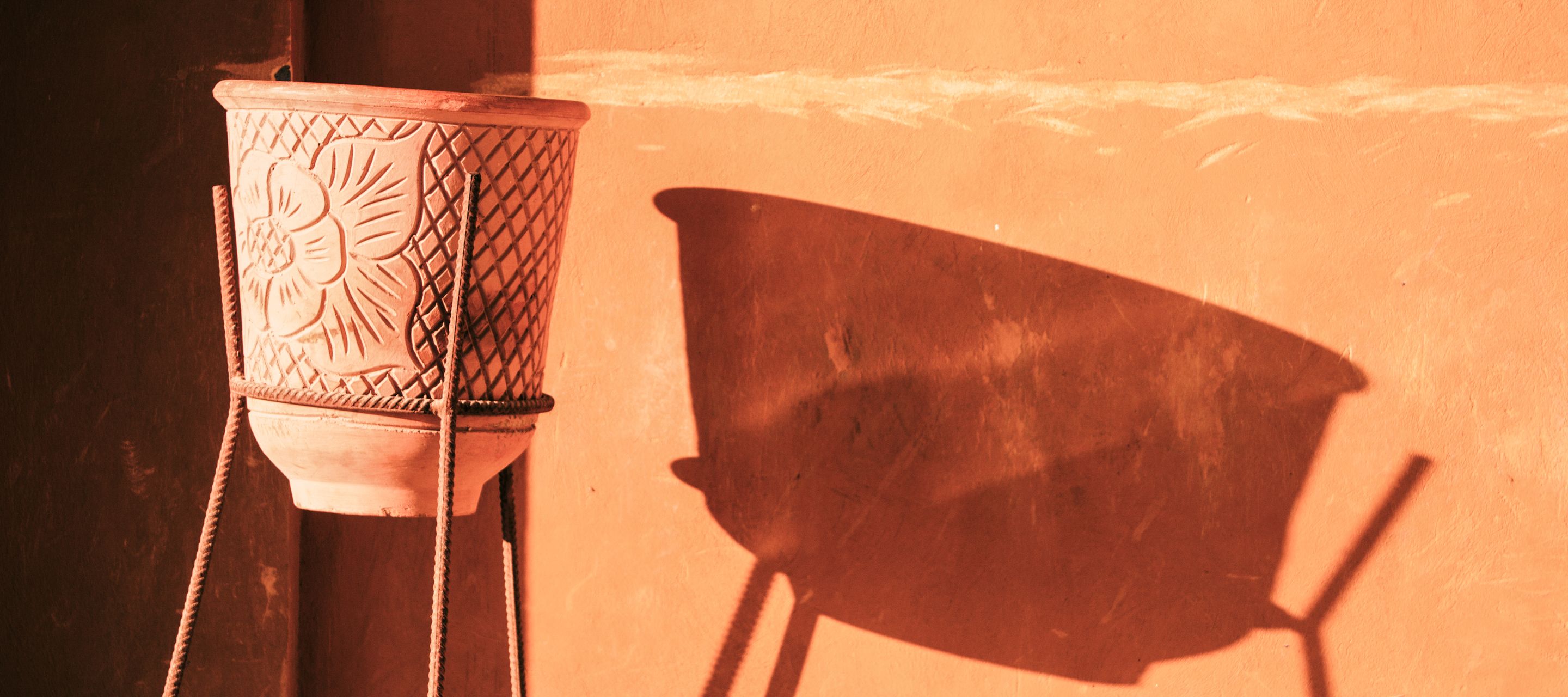 Der Terrakotta-Topf wirft einen langen Schatten an eine Hausmauer in El Gouna