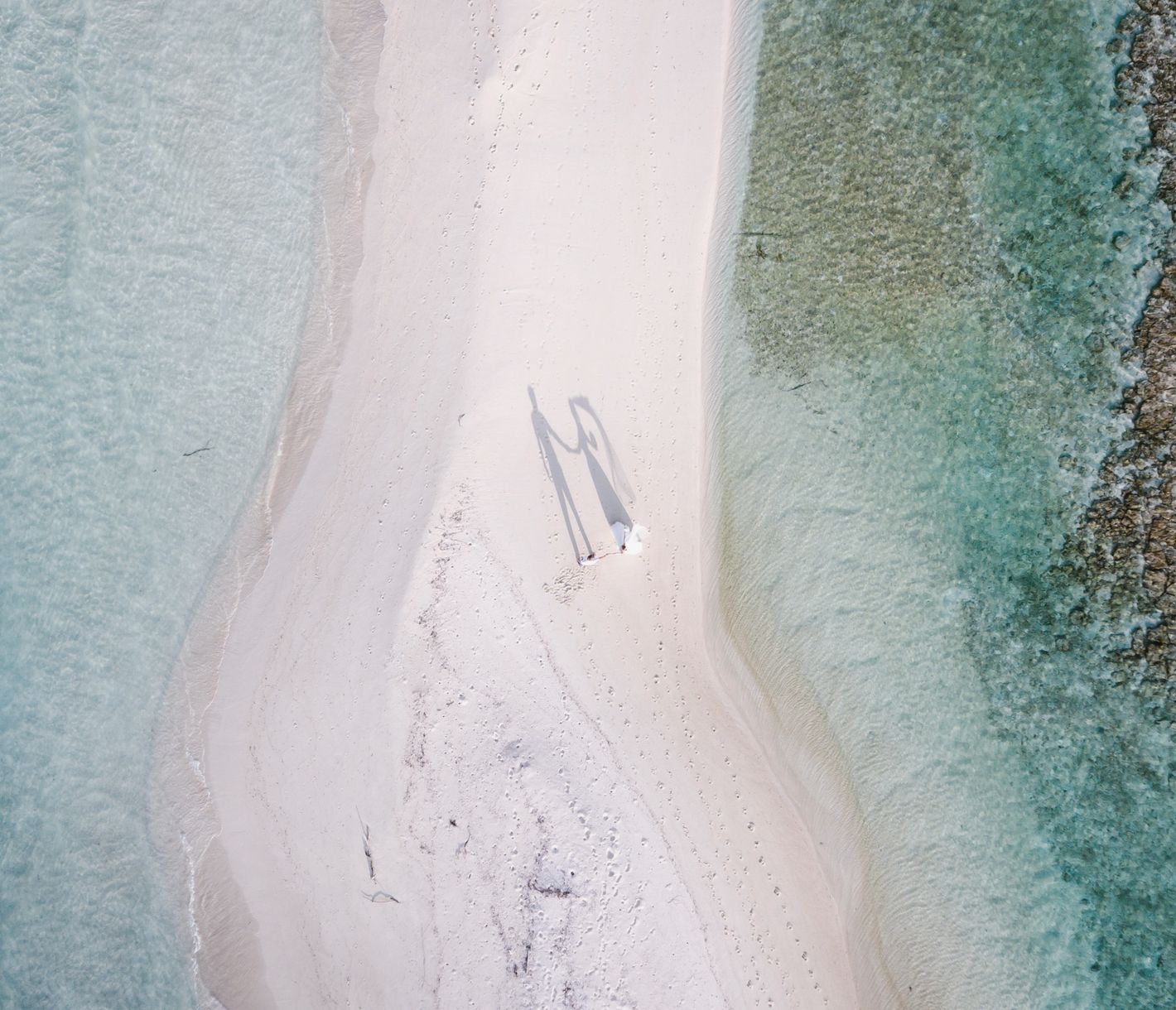 Hand in Hand über Sand, wo die Welt nur Himmel und Meer kennt.