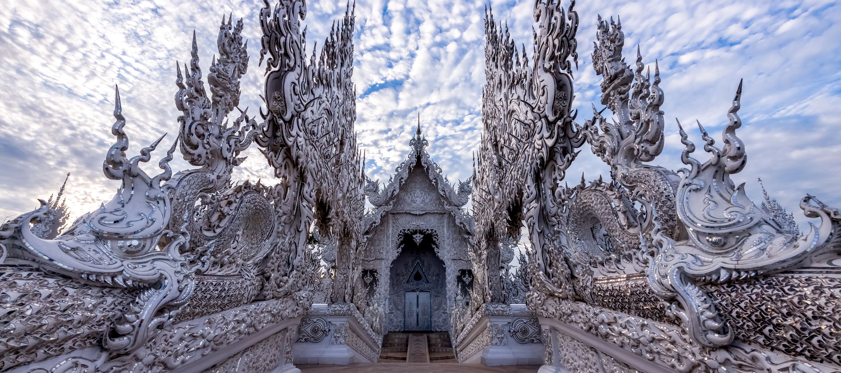 Der in weiss strahlende Wat Rong Khun ist einer der aussergewöhnlichsten Tempel Thailands.