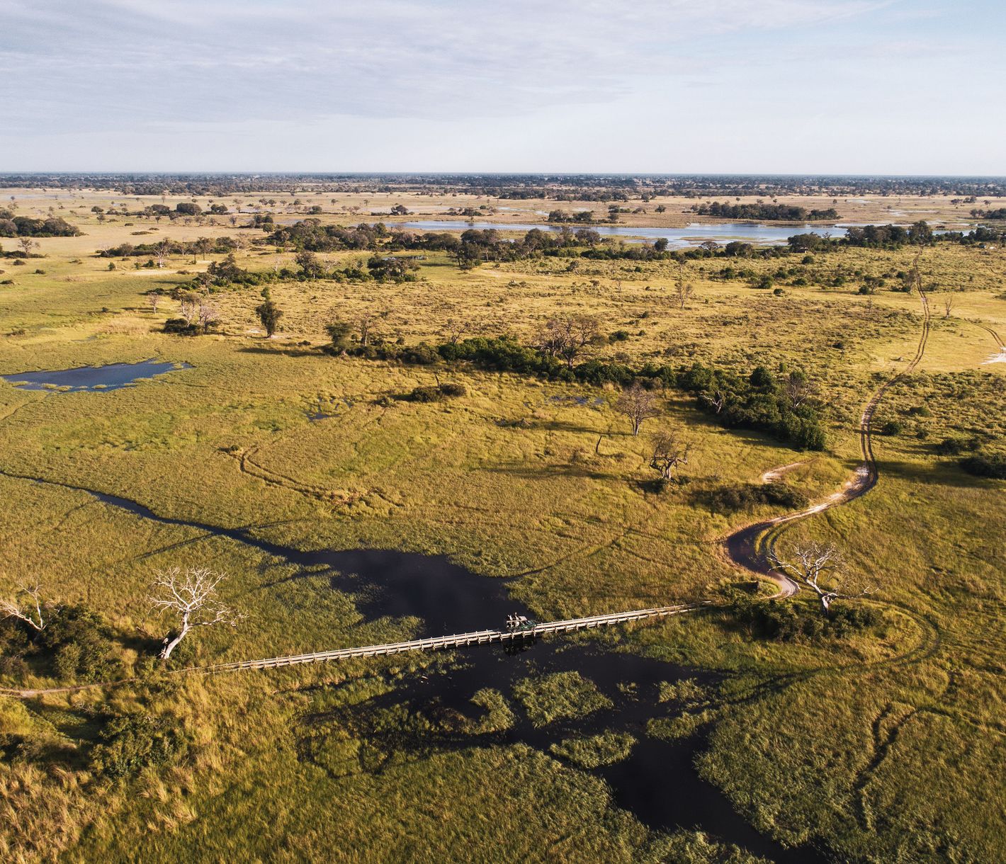 Eine Sandpiste mit einer kleinen Brücke im Okavango-Delta