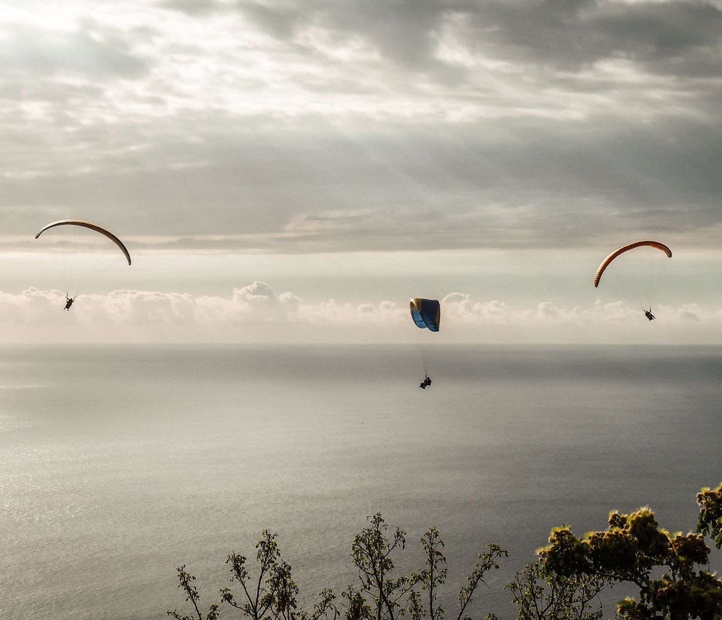 Gleitschirmflieger bei Sonnenuntergang über der Westküste von La Réunion