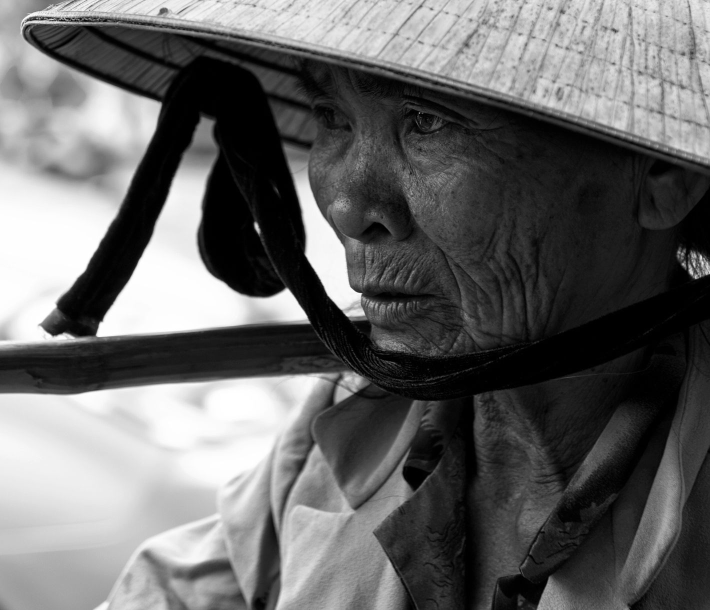 Erfahrene Streetfood-Verkäuferin mit vietnamesischem Reishut auf den Strassen von Hoi An.